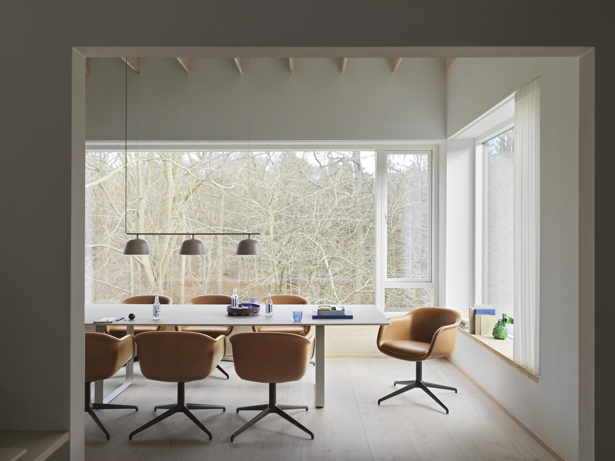 Fiber Conference Armchair w. Swivel Base in Cognac Refine Leather - 70/70 Table in Grey - Ambit Rail Lamp in Taupe - Platform Tray - Raise Glasses in Dark Blue