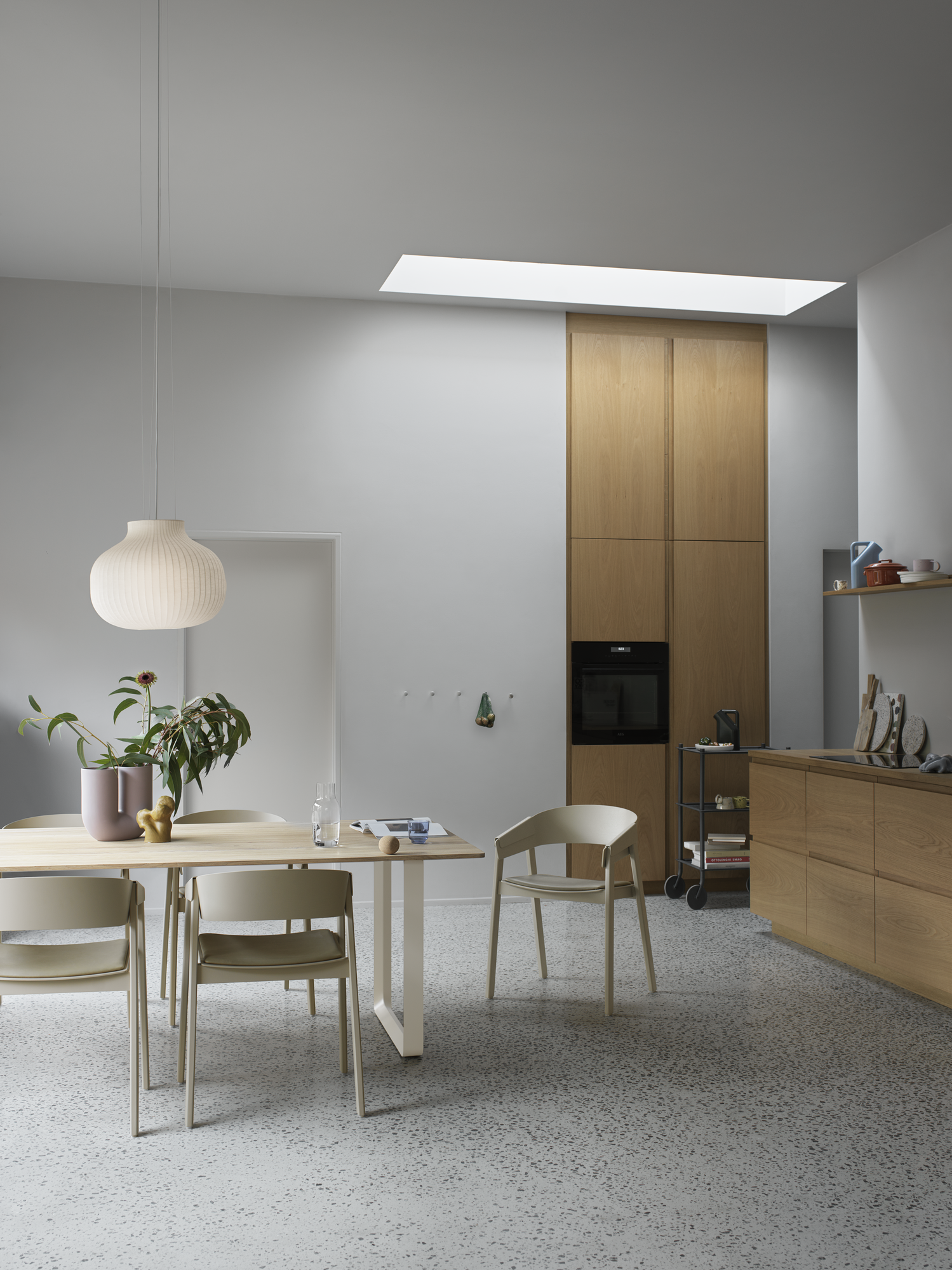 Cover Armchair in Dark Beige/Refine Leather Stone - 70/70 Table in Sand/Solid Oak 255x108 cm - Strand Pendant Ø45 - Kink Vase in Dusty Lilac - Flow Trolley - Dots in Aluminum