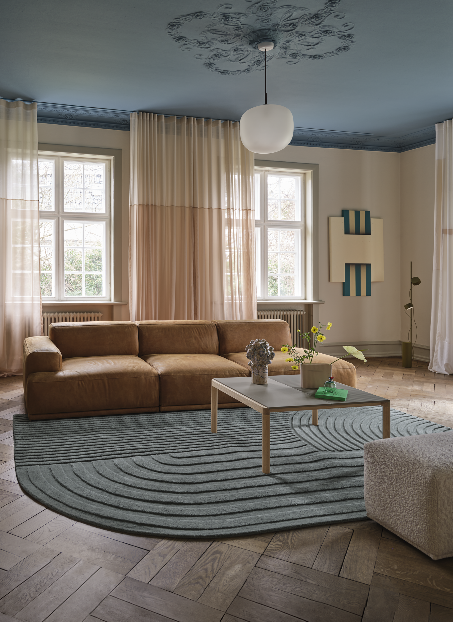 Connect Soft Modular Sofa in Grace Leather Cognac - Relevo Rug in Sage Green - Couple Coffee Table in Taupe - Echo Pouf in Hearth 7 - Post Floor Lamp in Brown Green - Rime Pendant Ø37 cm in black - Ridge Vase in Beige