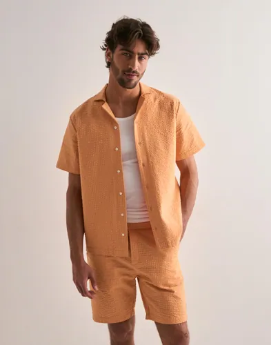 Orange seersucker-shorts från Ciszere med resår i midjan