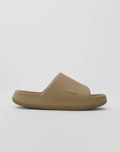 Bruna slides från Nike Calm Slide 2.0 med logga på sidan