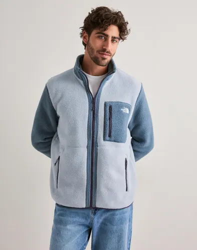Blå fleecejacka från The North Face med dragkedja och broderad logga på bröstficka