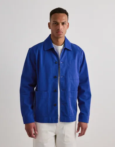 Beige overshirt från Selected med broderat tryck på ryggen och framfickor