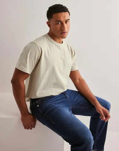 Beige oversized t-shirt från Neuw med logga på bröstet
