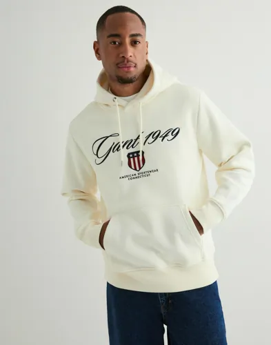 Beige hoodie från Gant med luva, magficka och broderad logga på bröstet