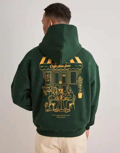 Grön hoodie från Qué Sera Sera med tryckt logga och magficka