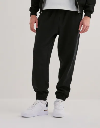 Svarta New Balance mjukisbyxor i French Terry med dragkedjefickor