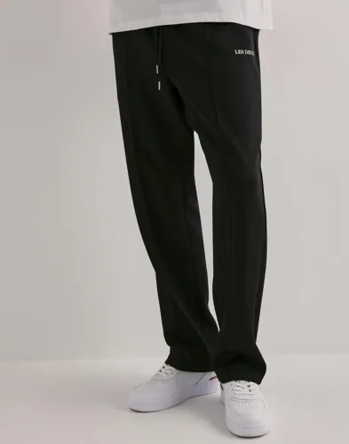 Bruna track pants från Les Deux med knytning i midjan och logga vid fickan