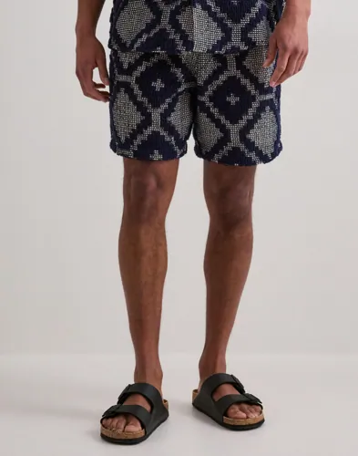 Blå frottéshorts från OAS med virkad struktur och resår i midjan