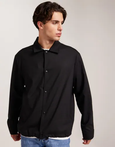 Svart coach-overshirt från J Lindeberg med tryckknappar
