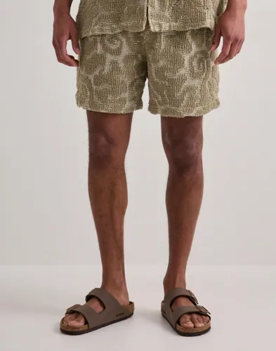Beige frottéshorts från OAS med virkad design och dragsko
