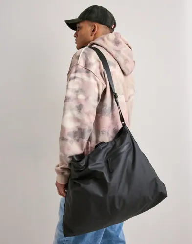 Svart tote bag från Rains med axelrem och ytterfack